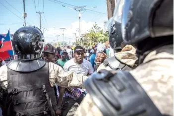  ?? — AFP photo ?? Demonstrat­ors confront police officers as they march in Port-au-Prince to protest against the government of Moise.