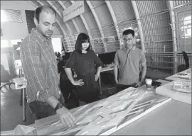  ??  ?? HTT ARCHITECTS Christos Kyratsous, left, Yayun Zhou and Chunhua Chiu look at a design for Hyperloop tubes over the Los Angeles River.