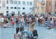  ??  ?? Am Abend atmet Rom durch: Besucher auf der Piazza Rotonda hören einem Straßenmus­iker zu.