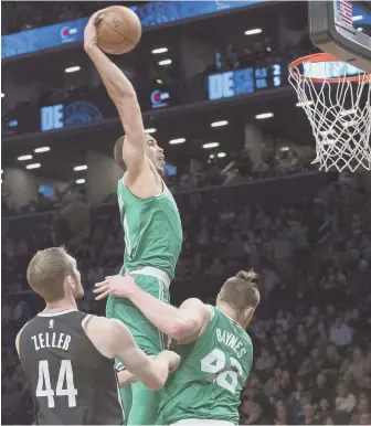  ?? AP PHOTOS ?? GREEN DAY: Above, Jayson Tatum slams one home over Brooklyn's Tyler Zeller (and teammate Aron Baynes) during last night's victory. Below, Baynes celebrates.