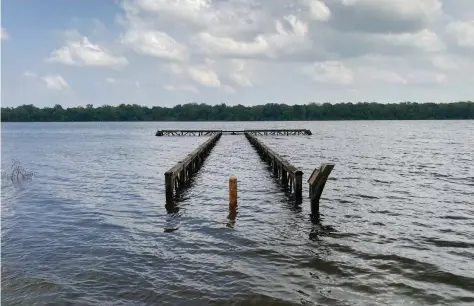  ??  ?? A fishing pier at Regional Park was more of a pier for fish Monday as high water from the Arkansas River raised the level of Lake Langhofer, shown here, which is an oxbow of the river. (Pine Bluff Commercial/Byron Tate)