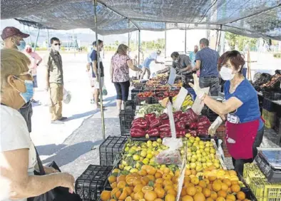  ?? EFE / DANIEL PÉREZ ?? Varios ciudadanos se acercan a uno de los puestos del mercadillo del recinto ferial de Málaga, ayer.