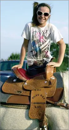  ?? MARK HUMPHREY ENTERPRISE-LEADER ?? ShaLynn Napier, 12, of West Fork, keeps herself on the horse with one foot in the stirrup. Napier won the saddle by being the Lincoln Riding Club Play Day overall points champion for 2011. She is also sporting a buckle for taking first in her age group, 10-13, in 2011.