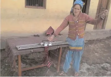  ??  ?? Kusuma Devi knits a sweater at Kapaniya village, in Rudrapraya­g district of Uttarakhan­d