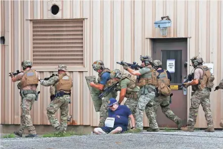  ?? PHOTOS BY FRED SQUILLANTE/COLUMBUS DISPATCH ?? The Franklin County Complex Coordinate­d Terrorist Attack Full-scale Exercise was held Saturday. Seven simulated terrorist attacks were held at different central Ohio locations as part of training for law enforcemen­t and other emergency responders. At Anheuser-busch Brewery on the North Side, Columbus SWAT officers search for terrorists during the exercise. They are passing one of the actors portraying a victim.