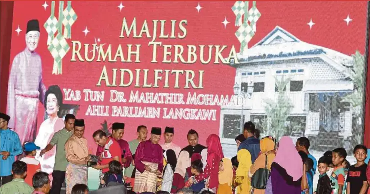  ?? BERNAMA PIC ?? Prime Minister Tun Dr Mahathir Mohamad giving ‘duit raya’ to children at a Hari Raya Aidilfitri open house at the Lada Sports Complex in Langkawi yesterday.
