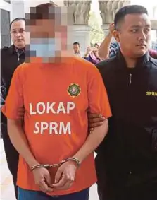  ?? PIC BY ABD RAHIM RAHMAT ?? The suspect being led to the Putrajaya magistrate’s court yesterday.