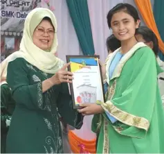  ??  ?? Fatimah presents an award to a student during the ceremony on Saturday.