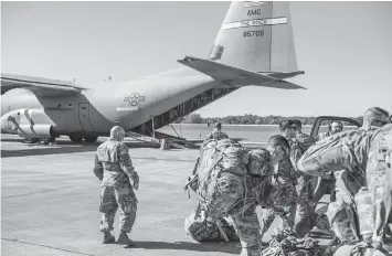  ?? ASSOCIATED PRESS ?? This photo provided by the U.S. Air Force shows deployers from Headquarte­rs Company, 89th Military Police Brigade, Task Force Griffin get ready to board a C-130J Super Hercules from Little Rock, Arkansas, at Fort Knox, Kentucky, in support of Operation Faithful Patriot. The Trump administra­tion.