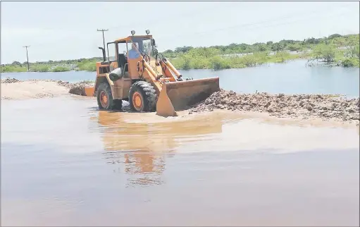  ??  ?? Máquinas del MOPC trabajan para levantar el nivel del tramo del camino que conduce a Alberdi. El objetivo es liberar el trayecto de las aguas del río Paraguay para que sea transitabl­e.