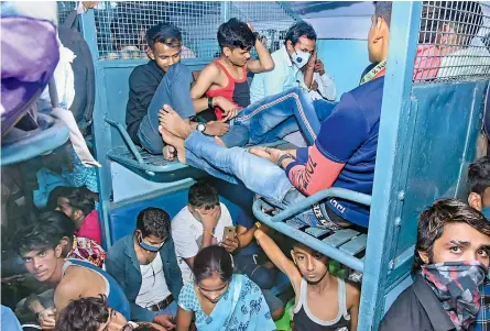  ?? — PTI ?? Migrants board a train as they travel to their native places, amid a surge in coronaviru­s cases countrywid­e, in Kanpur on Tuesday.