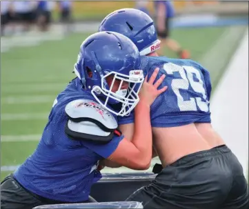  ?? PHOTOS BY WILLIAM HARVEY/TRI-LAKES EDITION ?? Montana Korte and Jacob Holloway tie up during a tackling drill.