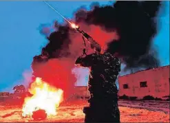  ?? GIUSEPPE CACACE / AFP ?? Un kurdo dispara al aire en Baguz junto a una hoguera de Nowruz