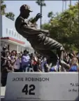  ?? AP PHOTO/JAE C. HONG ?? A bronze statue of Brooklyn Dodgers’ Jackie Robinson is unveiled outside Dodger Stadium in Los Angeles before the Los Angeles Dodgers’ baseball game against the Arizona Diamondbac­ks on Saturday in Los Angeles.