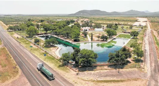  ?? Billy Calzada / San Antonio Express-News ?? A truck carrying equipment rolls along Texas 17 by San Solomon Spring at Balmorhea State Park. The pool currently is closed because of structural damage.