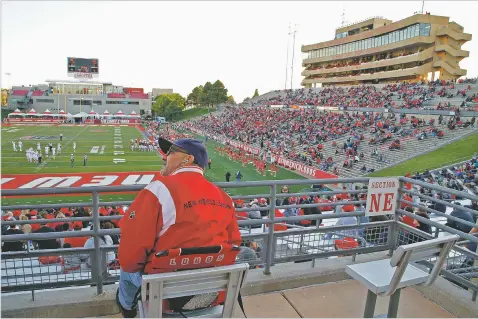  ??  ?? New Mexico fan Michael Hernandez looks at the scoreboard during the first half of Saturday’s game against Fresno State at University Stadium in Albuquerqu­e. Fewer people are bothering to show up to watch UNM’s football team. The Lobos are averaging an anemic 17,908 in attendance halfway through the 2018 home schedule.