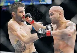  ?? John Locher Associated Press ?? ROBBIE LAWLER, right, lands a punch to the jaw of Carlos Condit during their UFC welterweig­ht championsh­ip bout. Lawler won, and he wants a rematch.