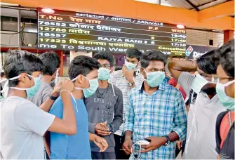  ?? — AFP ?? Young tourists wear facemasks as a preventive measure against the spread of the Covid-19 coronaviru­s outbreak at the Bangalore City Railway Station on Wednesday.