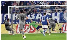  ??  ?? Der Brasiliane­r Otavio (l.) verlädt Schalke-Torwart Ralf Fährmann (M.) beim zweiten Strafstoß für Porto.