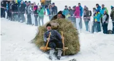  ?? Foto: Ralf Lienert ?? Mit Hörnerschl­itten fahren mutige Teilnehmer beim traditione­llen Pfrontener „Schalengge­n“-rennen den Berg hinab.