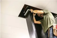  ?? Staff photo by Hunt Mercier ?? ■ Scott Strange of Arklatex Drywall installs a brace for ceiling tiles Monday in a locker room at Texas High School’s aquatic center at Texarkana College. The grand opening of the renovated center will be in August.