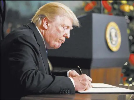  ?? Alex Brandon The Associated Press ?? President Donald Trump signs a proclamati­on Dec. 6 in the Diplomatic Reception Room of the White House. Trump recognized Jerusalem as Israel’s capital despite Arab, Muslim and European opposition to the move.