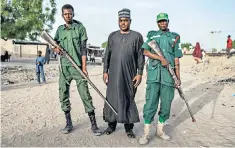  ??  ?? Bunu Mustapha Bukar, centre, and other hunters are helping the Nigerian military operation