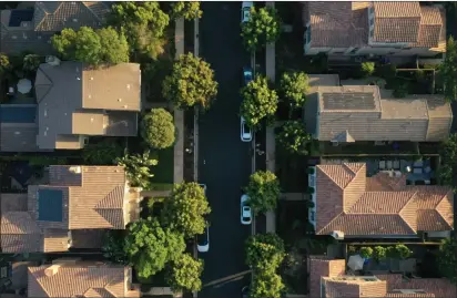  ?? Bloomberg photo by Bing Guan ?? Replacing your gas furnace, water heater, stove, and clothes dryer promises to lock in long-term environmen­tal and economic benefits – but beware of surprise costs. Shown, single-family homes in San Diego, Calif.