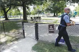  ?? AP PHOTO ?? A police officer marks off a playground near the baseball field in Alexandria, Va., yesterday where House Majority Whip Steve Scalise of Louisiana and others were shot during a congressio­nal baseball practice.