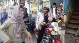  ??  ?? KUNDUZ: A Taleban fighter sits on his motorcycle adorned with a Taleban flag in a street in Kunduz, Afghanista­n. — AP