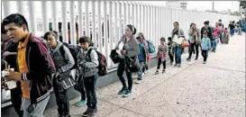  ?? GREGORY BULL/AP ?? Asylum-seekers line up in July to enter the U.S near the port of entry in Tijuana, Mexico.