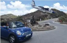  ?? ALAIN DUZANT/SXM PHOTOGRAPH­Y.COM ?? A Winair Twin Otter plane prepares to land in St. Barts. The airstrip is just below a traffic roundabout.