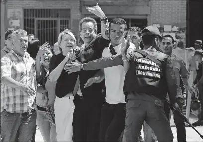  ?? [WIL RIERA/THE ASSOCIATED PRESS] ?? Venezuelan General Prosecutor Luisa Ortega, left foreground, is surrounded by loyal employees as she is barred from her office by security forces in Caracas. Ortega was taken from the scene by friends on a motorcycle Saturday.