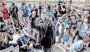  ?? — AFP photos ?? Hong Kong pro-democracy activist Mike Lam (centre) gestures after speaking with the press outside Ma On Shan police station in Hong Kong, where he and 46 other dissidents were each charged with one count of ‘conspiracy to commit subversion’ under the city’s new national security law.