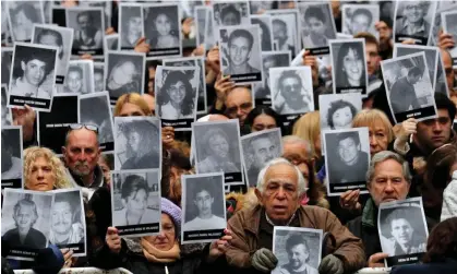  ?? Photograph: Marcos Brindicci/Reuters ?? People hold up portraits of victims of the 1994 bombing of the Argentinia­n Israeli Mutual Associatio­n, in Buenos Aires, Argentina, on 18 July 2018.