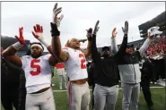  ?? PAUL SANCYA - THE ASSOCIATED PRESS ?? FILE - In this Nov. 30, 2019, file photo, Ohio State’s Baron Browning (5), Chase Young (2), linebacker­s coach Al Washington and head coach Ryan Day celebrate after a victory over Michigan in an NCAA college football game in Ann Arbor, Mich. Across the country universiti­es have begun the process of playing through a pandemic. As athletes return to campus, what are they signing up for? Ohio State and Missouri have pledges they are requiring athletes or their parents sign before the players can take part in voluntary workouts at team facilities.