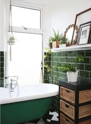  ??  ?? BATHROOM Margy painted the underside of the bath dark green and the chrome feet black to help it blend into the scheme. Plants and charity shop frames make a striking display