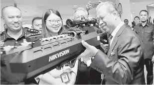  ?? — Gambar Bernama ?? LAWATAN: Muhyiddin mencuba senjata dron jammer “UAV-D04JAI” ketika melawat di sekitar tapak pameran selepas Majlis Perasmian Forum ‘Intelligen­t Smart Prison’ di Ibu Pejabat Penjara Malaysia (IPPM) semalam.