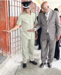  ?? FILE ?? Supt Albert Brown (left) points to the poor state of the cells at the Tower Street Adult Correction­al Centre in central Kingston during a tour by State Minister Rudyard Spencer on Monday, May 21.