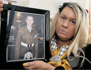  ??  ?? ANGRY: Linda Mccomiskie holds a photo of her son, Private Mark Connolly, who died in Germany
