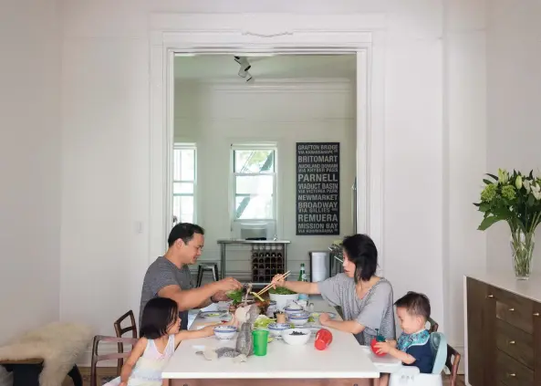  ??  ?? Demand for his consulting services keeps Anthony away from home at least three weeks in a month, so the time he has grounded at the family’s Brooklyn brownstone is precious. While Kai is American (from Michigan) the children are surrounded by reminders of their dual heritage, such as the kitchen wall hanging. OPPOSITE, CLOCKWISE FROM TOP LEFT: Anthony and Kai’s bright, white lounge looks out onto a leafy Park Slope street; Kai, August, Anthony and Cameron on the brownstone’s stoop; the couple bought the circa-1800s three- storey house 18 months ago from an older family who’d owned it for 50 years. “There were Reagan- era appliances in the kitchen,” says Kai. Luckily many original features, such as this marble fireplace, survived earlier renovation­s; Anthony cooks in the revamped – albeit temporary – kitchen.