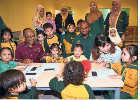  ?? — Bernama ?? Future bright stars: Teo (in white) having a chat with three-year-old Kayla Huwaida Mohd Amri, during a visit to the Brainy Bunch Internatio­nal Islamic Montessori child care centre at UTM in Skudai, Johor.