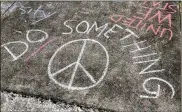  ?? JAMES BORCHUCK / THE TAMPA BAY TIMES ?? These messages were written by a group of Plant High School seniors on the sidewalk leading to their school in Tampa, Fla. “In addition to thoughts and prayers, action and policy need to take order,” said senior Catarina Sterlacci.