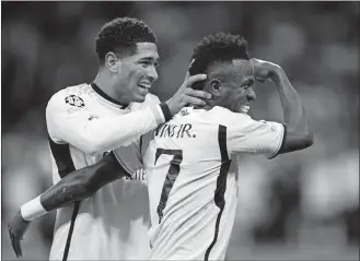  ?? MANU FERNANDEZ/AP PHOTO ?? Real Madrid’s Vinicius Junior, right, celebrates with his teammate Jude Bellingham after scoring his side’s opening goal during the Champions League round of 16 second leg soccer match on March 6 between Real Madrid and RB Leipzig at the Santiago Bernabeu stadium in Madrid, Spain.