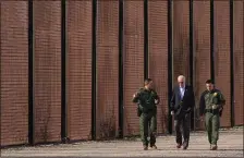  ?? ANDREW HARNIK, FILE — THE ASSOCIATED PRESS ?? Progressiv­es are pushing back against President Joe Biden’s new “middle-ground” immigratio­n policy, which pairs stronger deterrence measures for illegal border crossings with the opening of limited legal pathways for asylum seekers and migrants. Here, Biden walks with U.S. Border Patrol agents along a stretch of the U.S.-Mexico border in El Paso Texas last month.