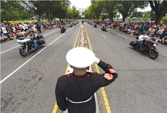  ?? Associated Press ?? ■ Marine Corps Staff Sgt. Tim Chambers salutes Sunday as motorcycli­sts participat­e in the 32nd Rolling Thunder demonstrat­ion in Washington. The event honors American prisoners of war and service members missing in action and calls attention to veterans’ issues.