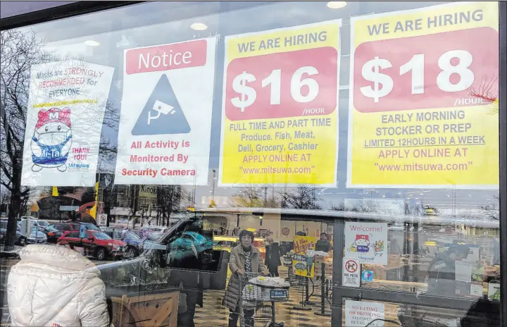  ?? Nam Y. Huh The Associated Press ?? Hiring signs displayed at a grocery store in Arlington Heights, Ill., in January. Wages and benefits, such as health insurance, grew 1 percent in the October-december quarter.
