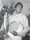  ??  ?? Althea Gibson smiles as she holds trophies she won by capturing the National women’s singles tennis championsh­ip, now the U.S. Open. Gibson, the first black to win Wimbledon and U.S. national titles, won the first of her two U.S. Opens, 61 years ago today.