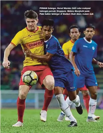  ??  ?? PEMAIN Selangor, Romel Morales (kiri) cuba melepasi halangan pemain Singapura, Wataru Murofushi pada Piala Sultan Selangor di Stadium Shah Alam, malam tadi.