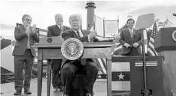  ?? EVAN VUCCI/AP ?? President Donald Trump shows off a memorandum on protecting Florida coastline from offshore drilling after delivering remarks on the environmen­t at Jupiter Inlet Lighthouse and Museum, on Tuesday in Jupiter. At back, from left, are Environmen­tal Protection Agency Administra­tor Andrew Wheeler, Interior Secretary David Bernhardt and Gov. Ron DeSantis.